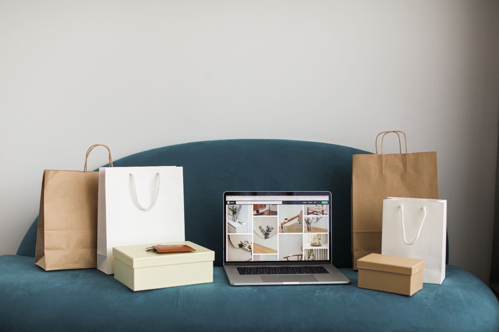 Shopping bags and gift boxes around a laptop showing an online store